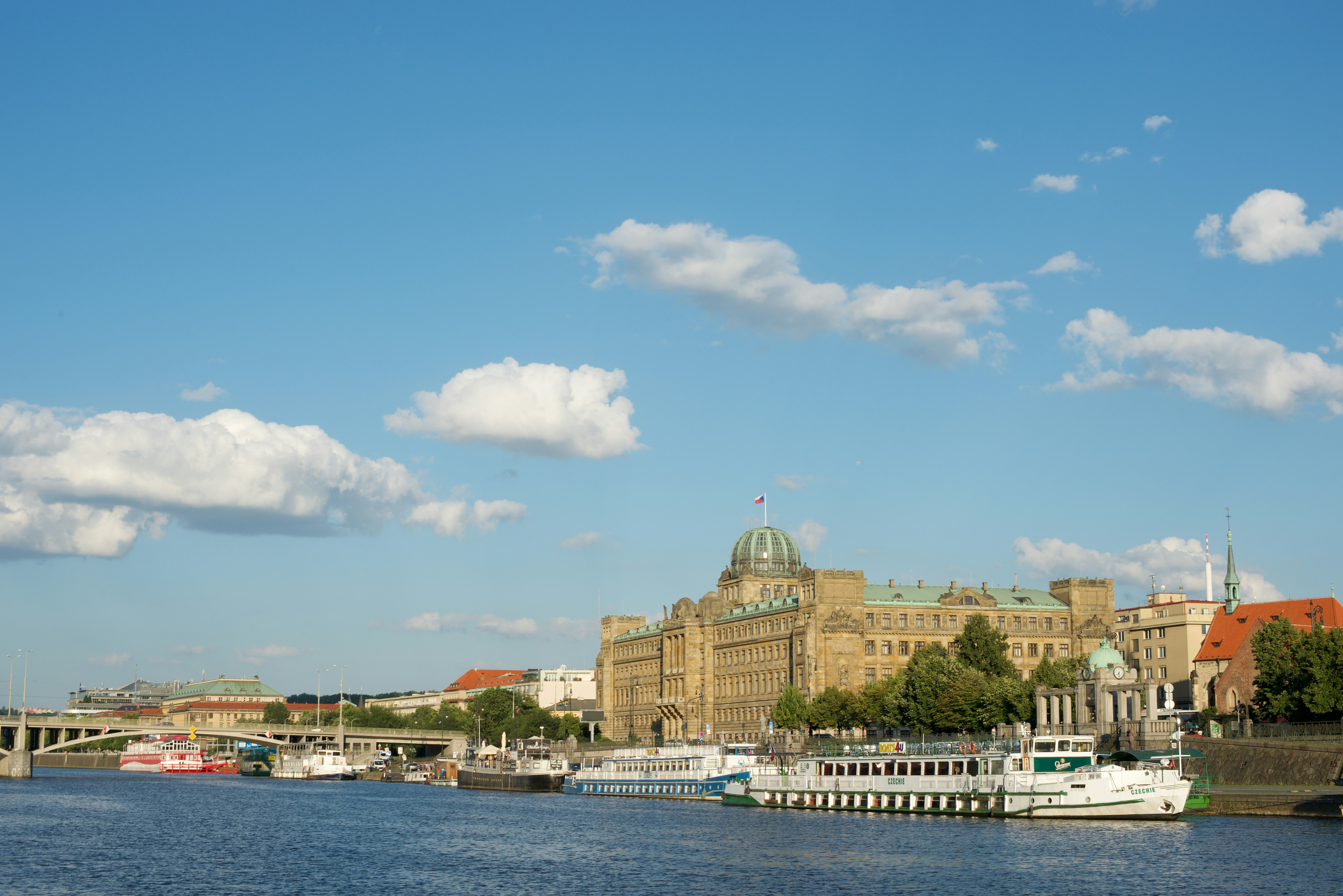 white and brown concrete building near body of water under blue sky during daytime